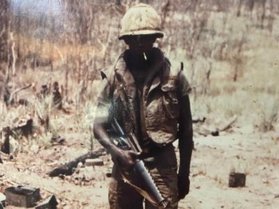 Vernell Varnado is standing in his unform while holding the gun.